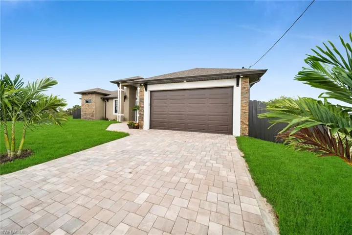 View of front of house featuring a garage and a front yard
