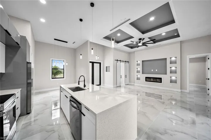 Kitchen featuring coffered ceiling, dishwasher, ceiling fan, beamed ceiling, and decorative light fixtures
