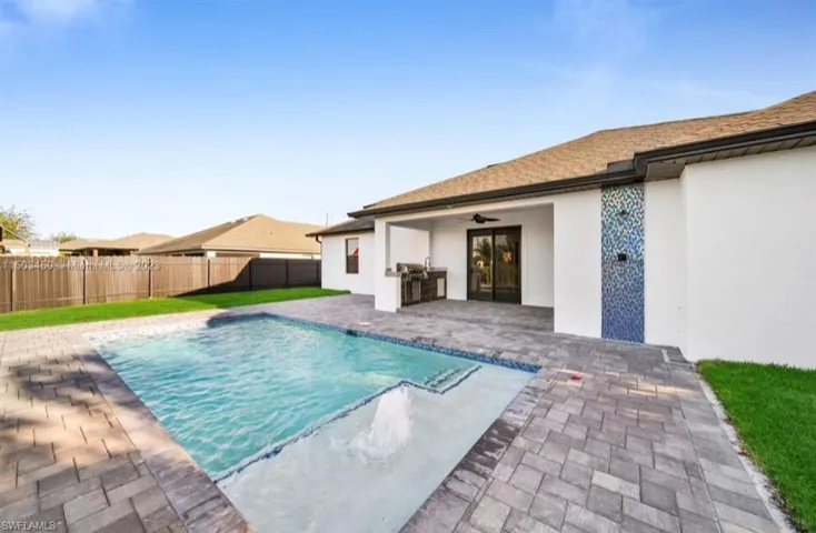 View of swimming pool with ceiling fan, a patio area, and a yard