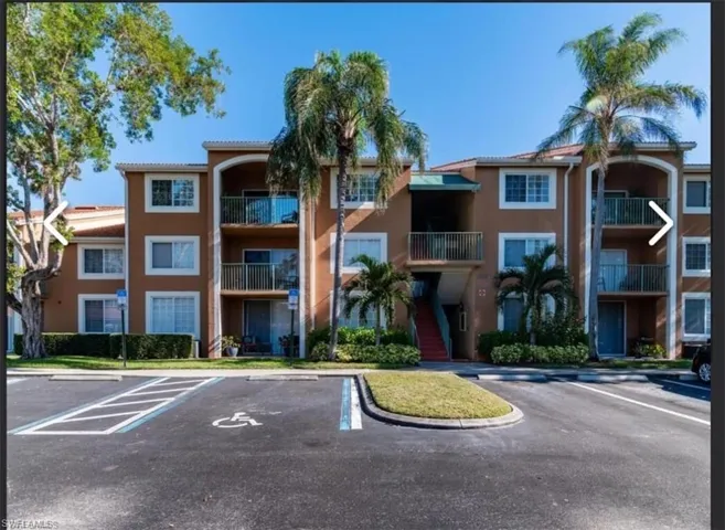 View of apartment building / complex with uncovered parking