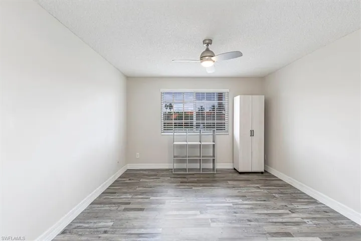 Unfurnished room with light wood-style floors, a textured ceiling, and a ceiling fan