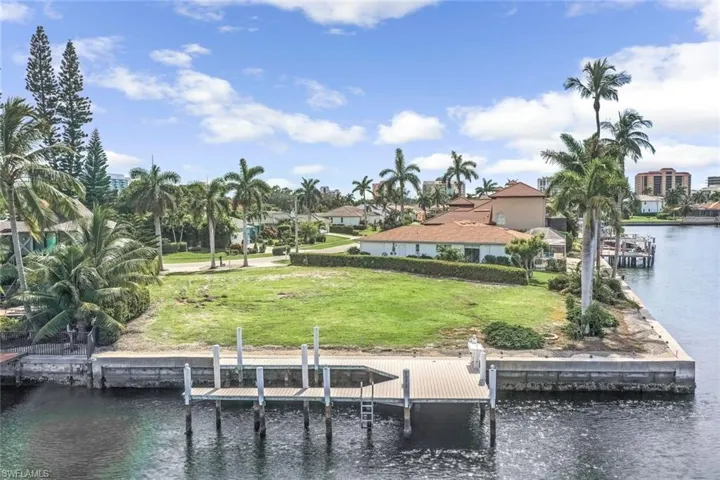 View of dock with a water view and a lawn