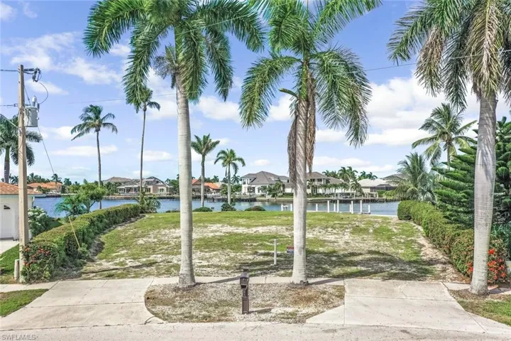 Surrounding community featuring a water view and a lawn