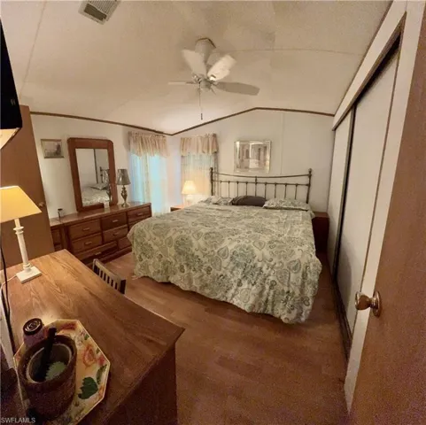 Main bedroom featuring vaulted ceiling, ceiling fan, and vinyl flooring.