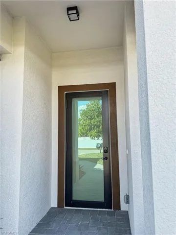Doorway to property featuring stucco siding