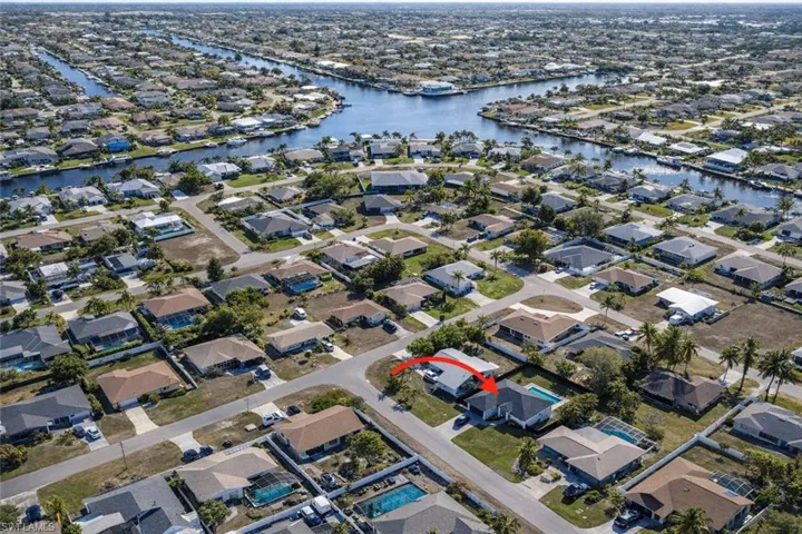 Aerial view of property's location with a nearby body of water and nearby suburban area