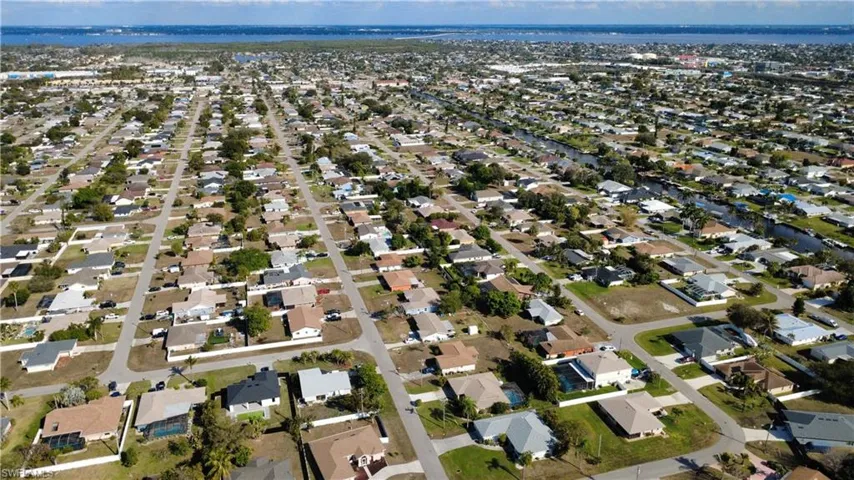 Aerial perspective of suburban area featuring a nearby body of water