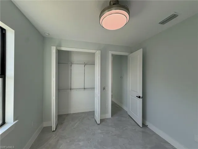 Unfurnished bedroom featuring a closet and baseboards
