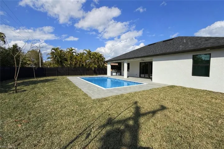 View of swimming pool featuring patio surround and a fenced backyard
