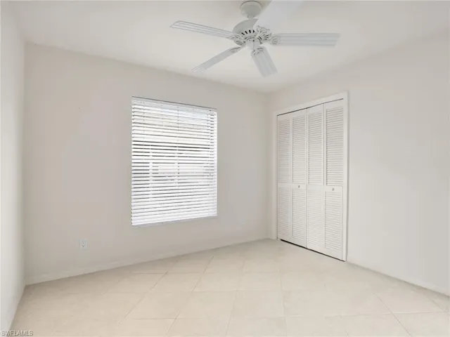 Unfurnished bedroom featuring a closet, ceiling fan, and light tile patterned flooring