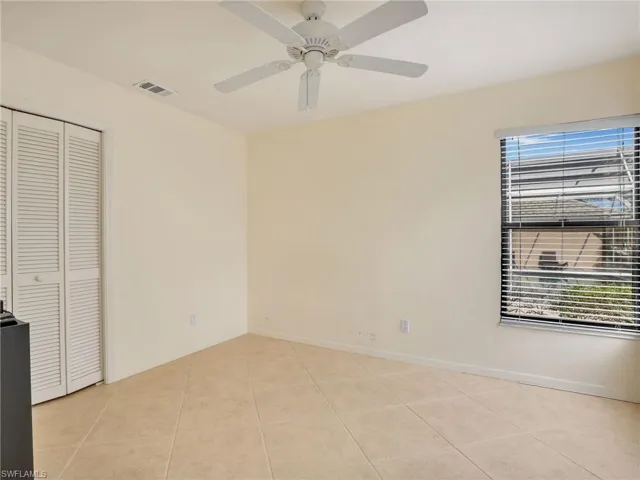 Unfurnished bedroom with multiple windows, ceiling fan, a closet, and light tile patterned flooring