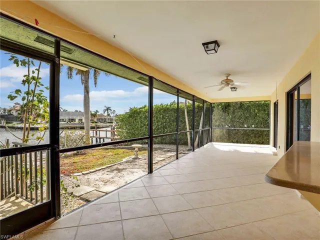 Unfurnished sunroom with a wealth of natural light, a water view, and ceiling fan