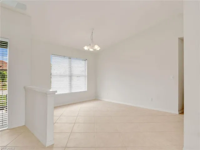 Spare room featuring light tile patterned floors and an inviting chandelier