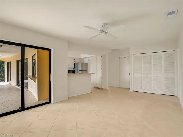 Unfurnished living room with ceiling fan and light tile patterned floors