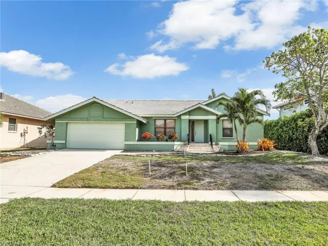 Ranch-style house with a garage and a front lawn