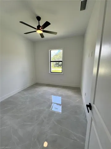Empty room with baseboards and a ceiling fan