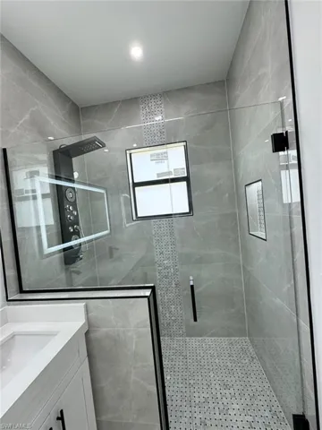 Bathroom featuring a stall shower, vanity, and recessed lighting