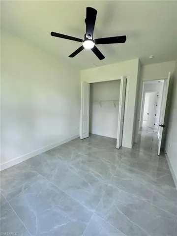 Unfurnished bedroom featuring a ceiling fan and a closet
