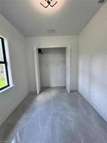 Unfurnished bedroom with a closet and baseboards