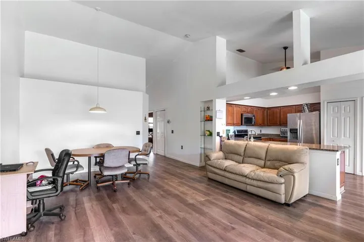 Living room with dark wood-style floors and high vaulted ceiling