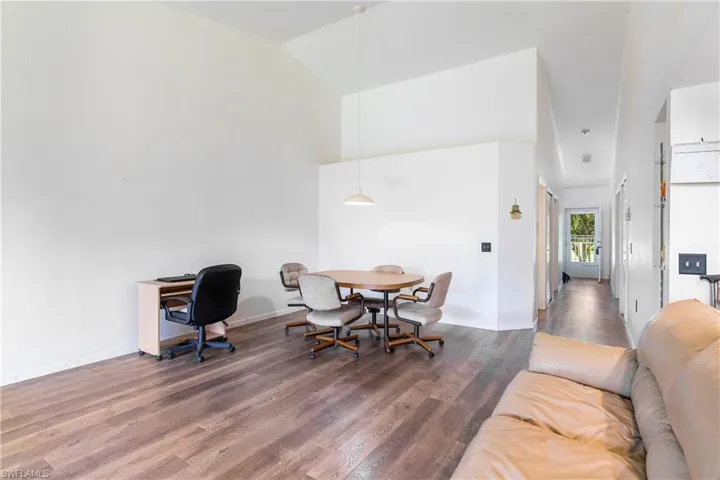 Home office featuring dark wood-style flooring and high vaulted ceiling