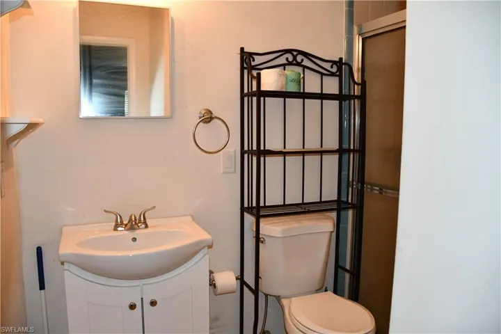 White vanity with an integrated sink and brass-finish faucet