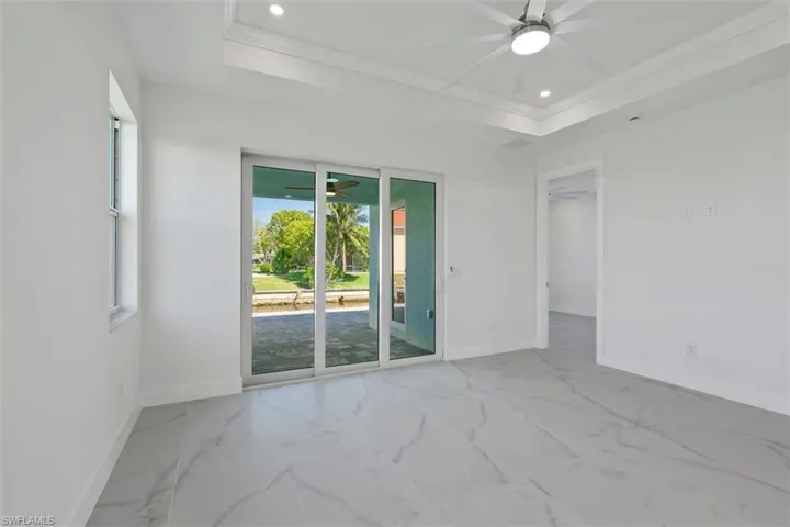 Empty room with baseboards, ceiling fan, and a raised ceiling