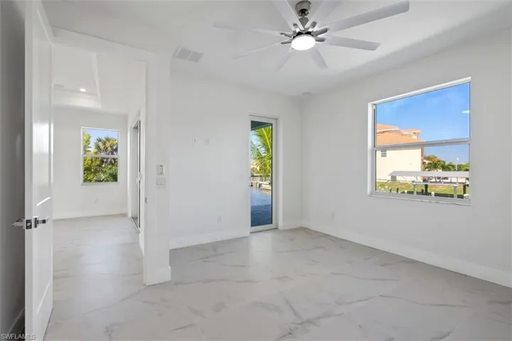 Spare room with baseboards, marble finish floor, visible vents, and a ceiling fan