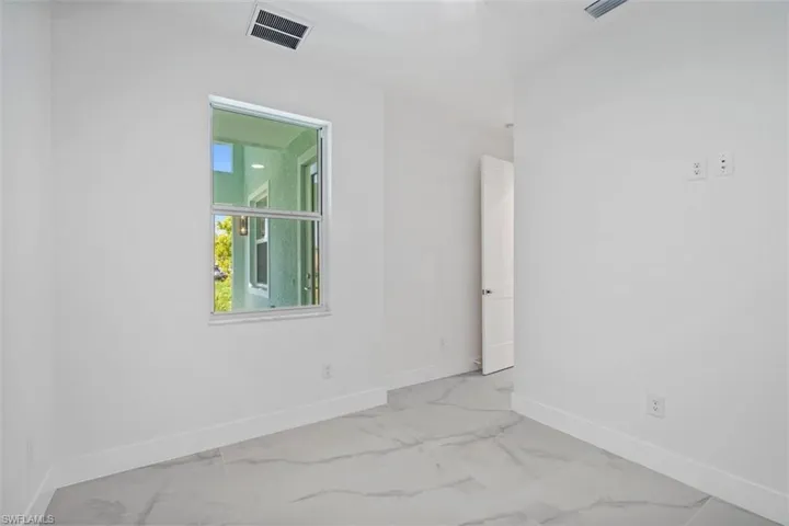 Unfurnished room featuring baseboards, marble finish floor, and visible vents