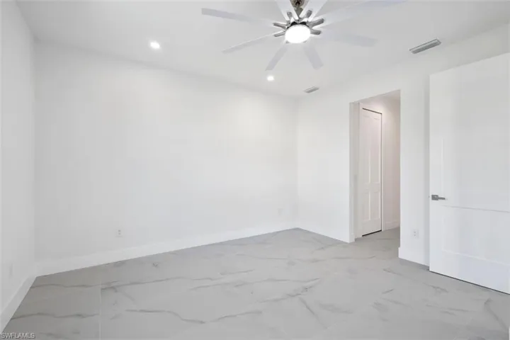Unfurnished room featuring marble finish floor, baseboards, and visible vents