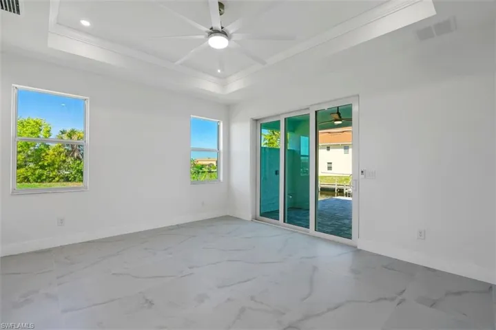 Unfurnished room with marble finish floor, baseboards, visible vents, and ceiling fan