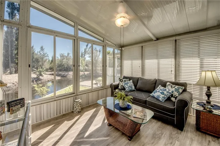 Sunroom / solarium with vaulted ceiling, a water view, and wood finished floors