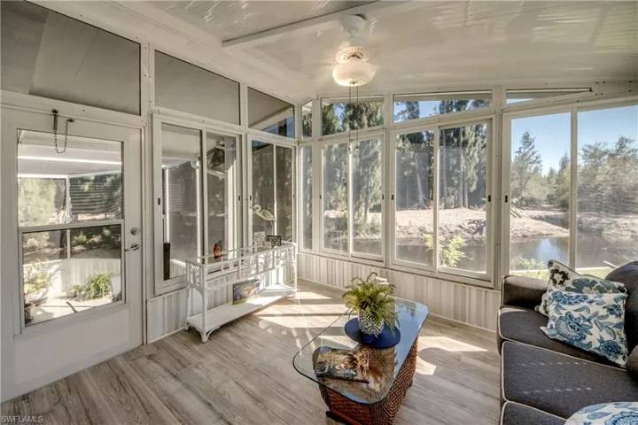 Sunroom featuring vaulted ceiling, healthy amount of natural light, a water view, and a ceiling fan