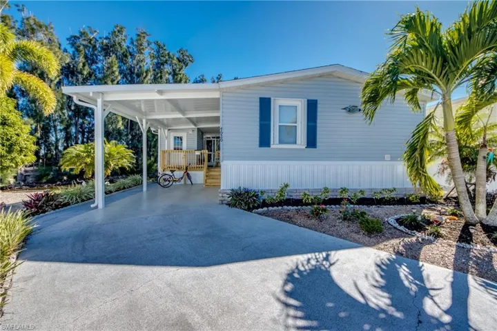 Manufactured / mobile home featuring an attached carport and concrete driveway