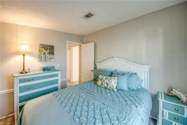Bedroom with a decorative wall and a textured ceiling