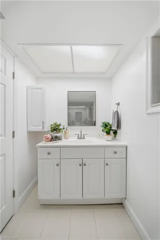 White vanity with undermount sink, ample storage cabinetry, and sleek hardware