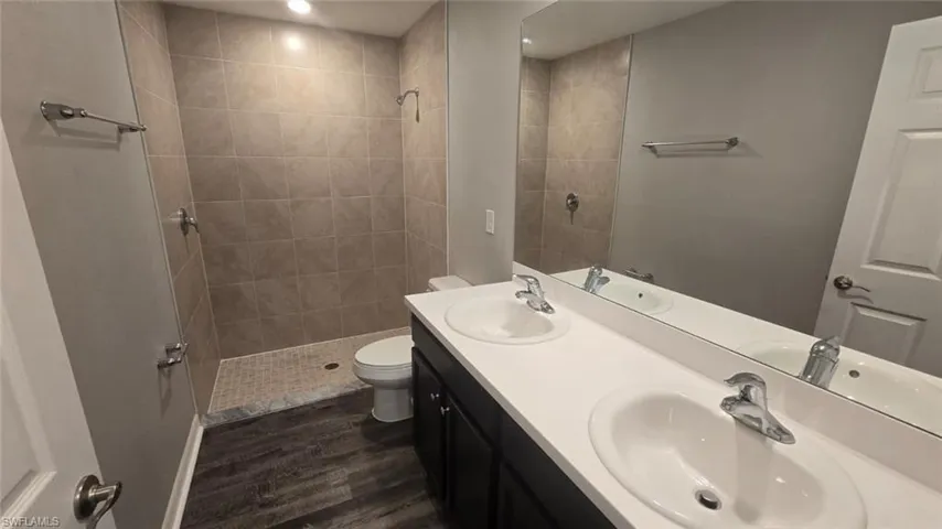 Bathroom with a stall shower, dark wood-style floors, and recessed lighting