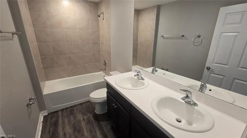 Bathroom featuring  shower combination and dark wood-type flooring