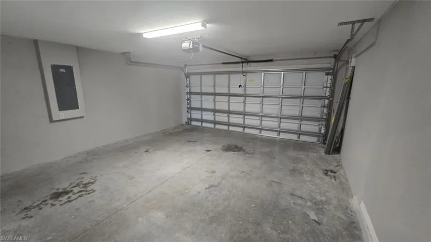 Garage with electric panel and a garage door opener