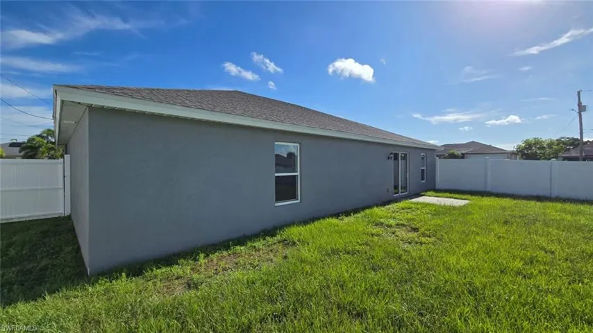 View of side of home featuring stucco siding and a shingled roof