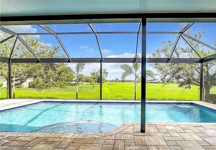 View of pool with a yard, a patio, and glass enclosure