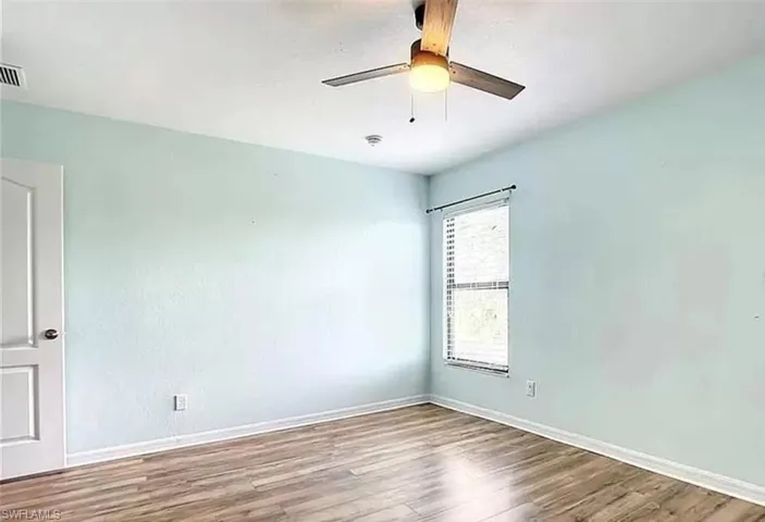 Empty room featuring ceiling fan and hardwood / wood-style floors