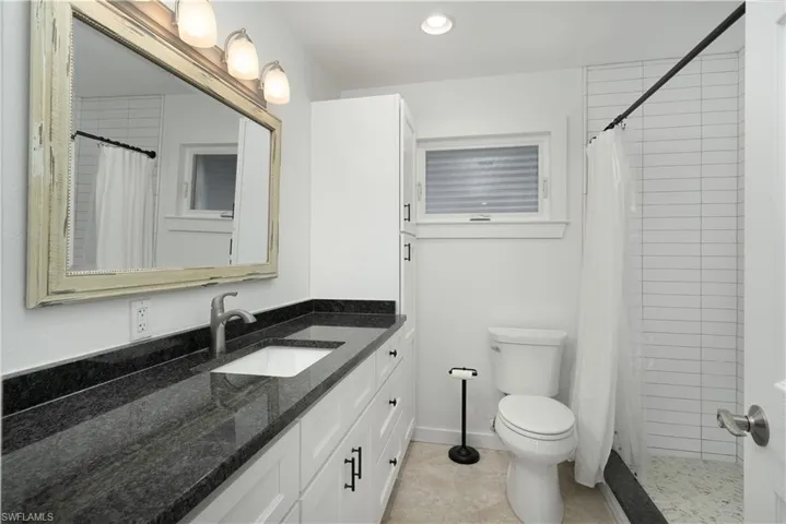 Guest Bathroom featuring tile patterned floors, vanity, a shower with shower curtain, and toilet