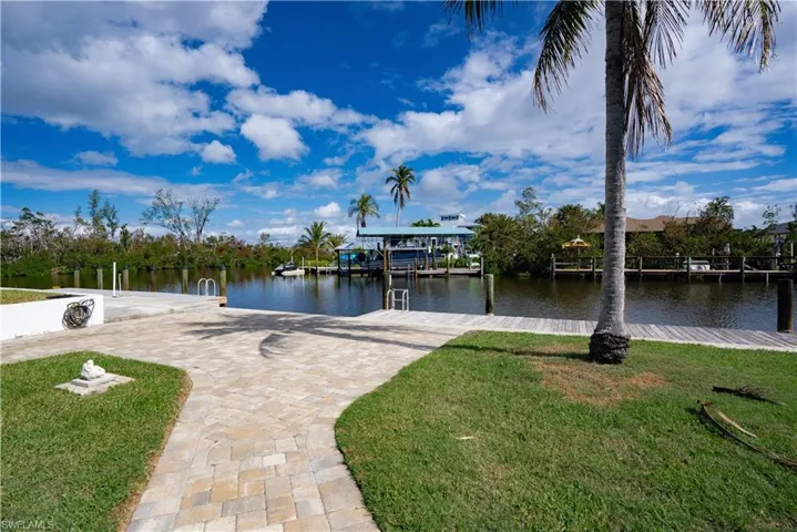 Dock area featuring a lawn and a water view