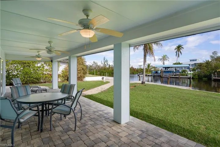 View of patio / terrace with ceiling fan and a water view