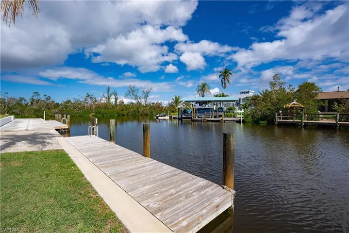 Dock area featuring a water view and a lawn