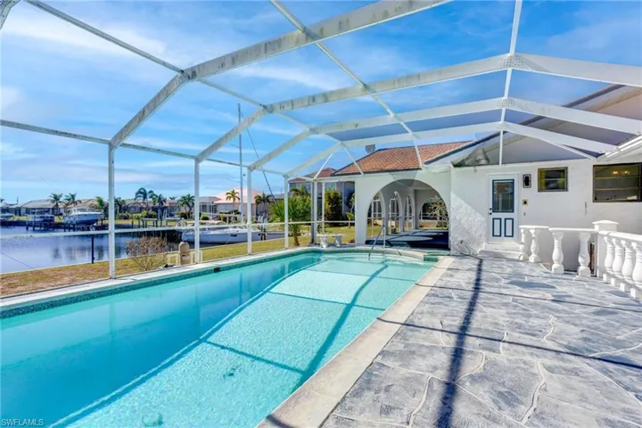 View of pool with glass enclosure, a water view