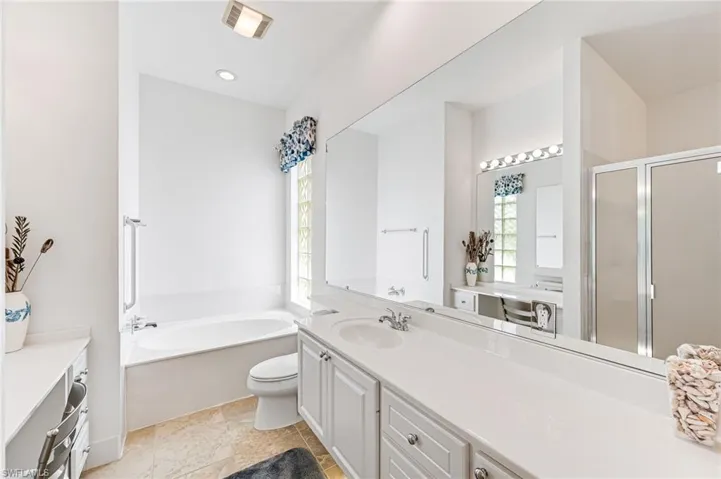 Bathroom featuring a bathtub, tile flooring, vanity, and toilet