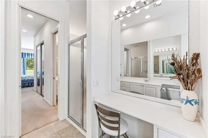 Bathroom with tile flooring, an enclosed shower, and large vanity