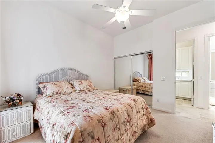 Bedroom featuring light colored carpet, a closet, and ceiling fan